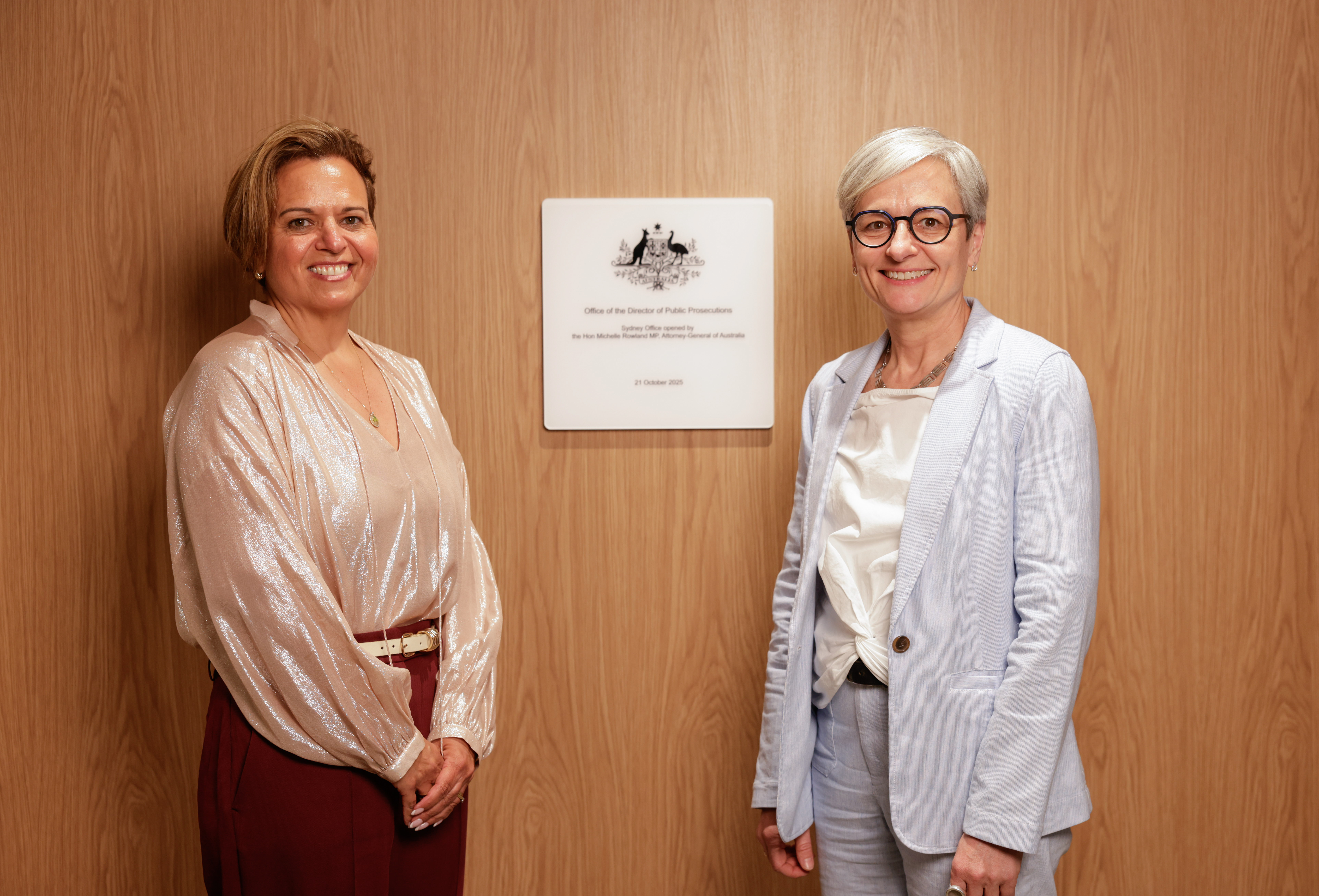 Attorney-General and Director standing in front of opening plaque